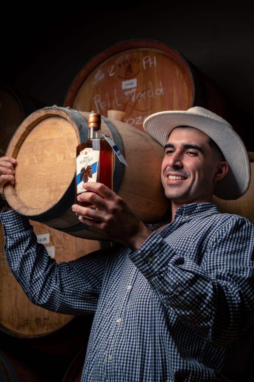 Alex Holding a bottle of Hamish's Heritage brandy aperitif and a min barrel.